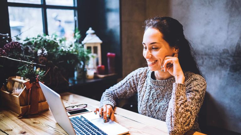 一位女士在她的小商店里用笔记本电脑工作