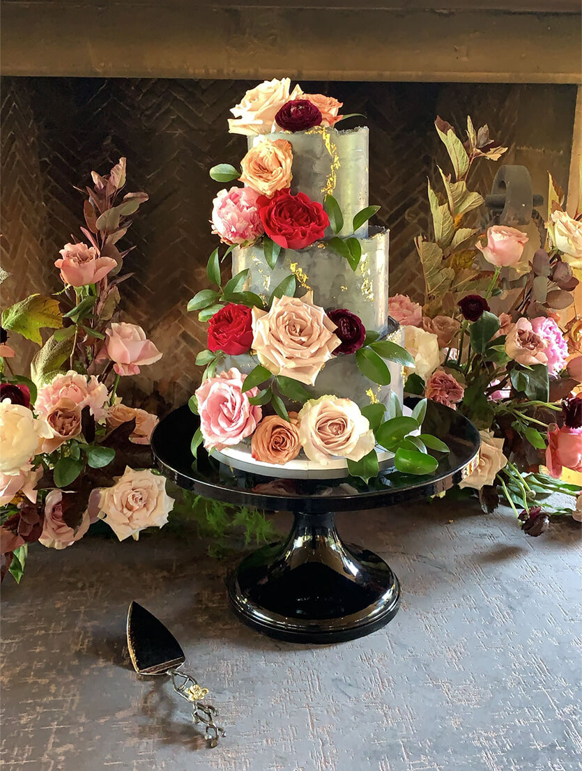 gorgeous green 3-tiered cake with assortment of flowers all over