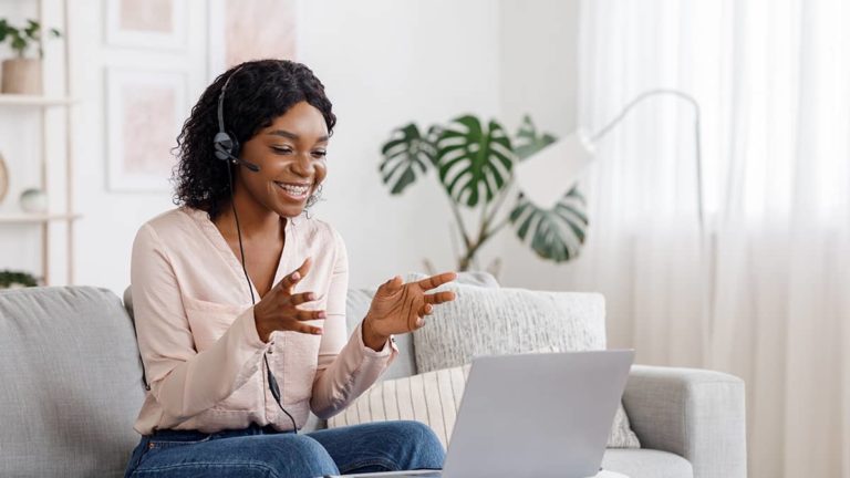 woman having a virtual meeting with out-of-state remote workers in her living room